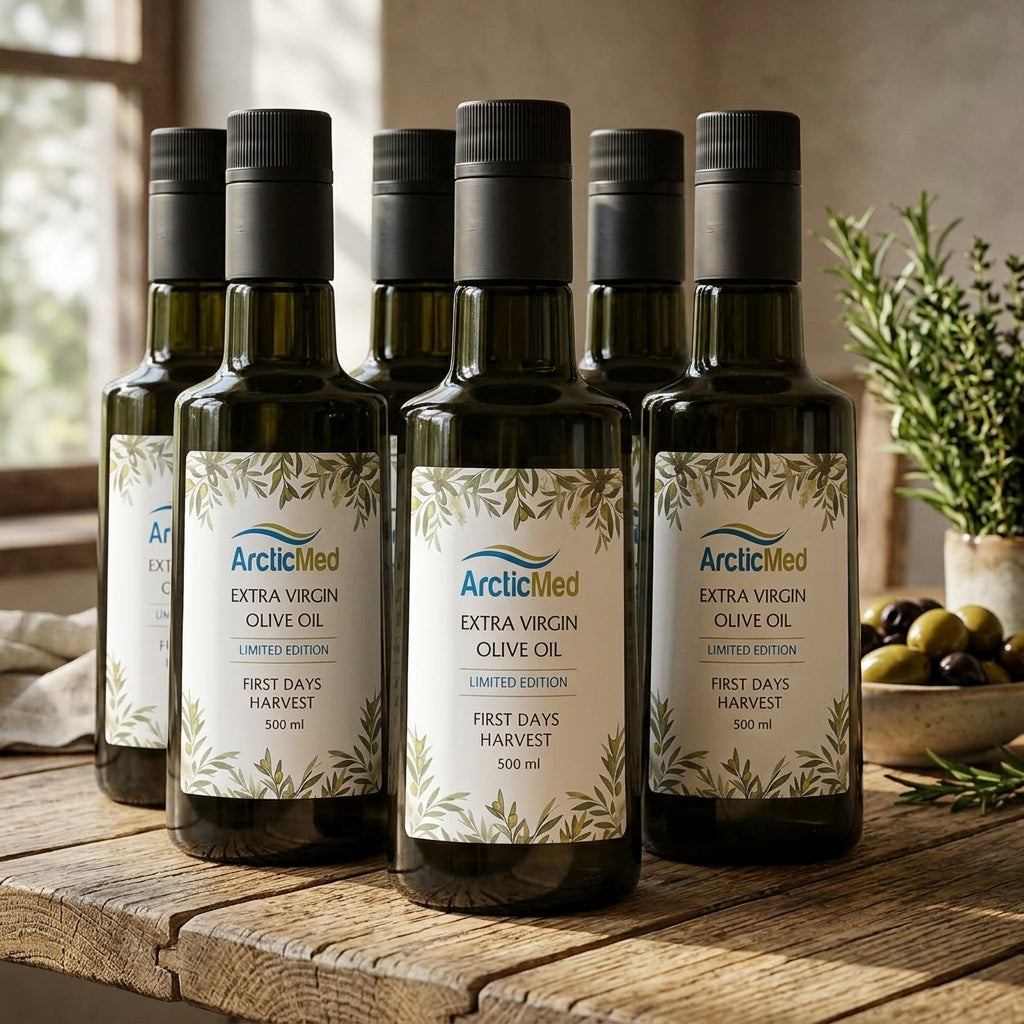 Six dark glass bottles of ArcticMed Extra Virgin Olive Oil 500 ml on a wooden table with olives and rosemary.